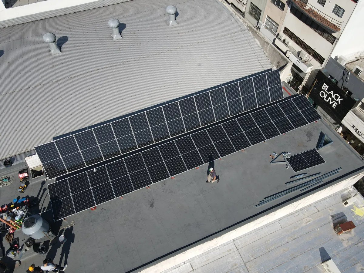 Técnicos de EcoApo instalando paneles solares sobre un techo